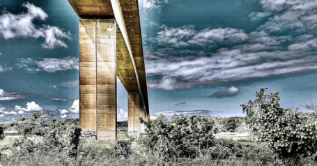 Concrete Colossus - Bideford Concrete bridge elevated above trees and landscape under a cloudy sky.